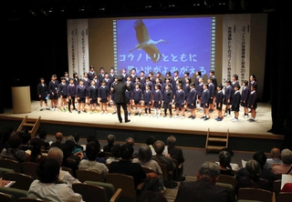 コウノトリ放鳥２０年に合わせて作曲された歌を披露する三江小学校４～６年生の児童たち＝豊岡市大手町