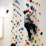 スタッフの指導を受けてクライミングに挑む山根久男さん＝豊岡市日高町伊府