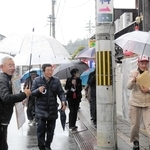 高橋雅樹さん（左から２人目）の案内で、りくゆかりのまち並みを歩く参加者＝豊岡市京町