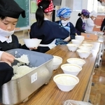 学校給食で提供されている無農薬のコウノトリ育むお米を配膳する子どもたち＝豊岡市庄境