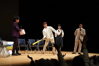 登壇者らのサイン入り色紙のプレゼント企画で、ボールを客席に打ち込むスポーツ解説者の桧山進次郎さん（中央）＝豊岡市立野町