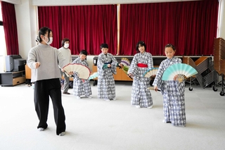 ＯＧの安本実央さん（左端）に教わって動きを確認する役者ら＝養父市関宮