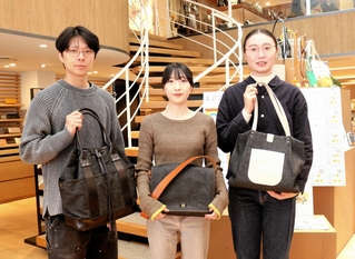 再生デニムのかばんをデザインし、商品化された２０２５年度卒業生たち（左から後藤大希さん、池田桜子さん、大越彩さん）＝豊岡市中央町