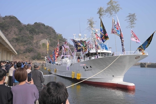大漁旗を掲げて入港する新造船「大和丸」＝浜坂漁港