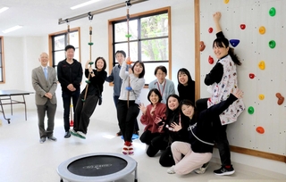 しらゆり診療所の跡地に、放課後等デイサービスなどの「スローウォーク」が移転した。運動スペースに集まるスタッフたち＝豊岡市小田井町