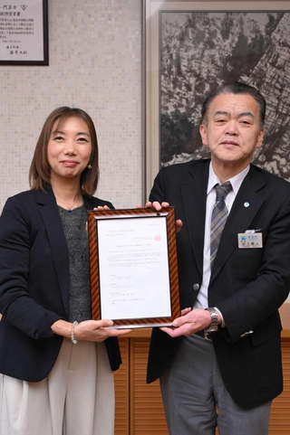 「日本で最も美しい村」の再認定通知書を手にする香美町小代協議会会長の中村美和子さん（左）と浜上勇人町長＝香美町役場