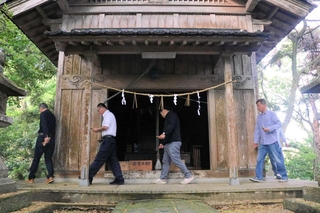 竹の札を手に、神社の周りを回って安全を祈願する住民たち＝豊岡市田結