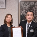 「日本で最も美しい村」の再認定通知書を手にする香美町小代協議会会長の中村美和子さん（左）と浜上勇人町長＝香美町役場