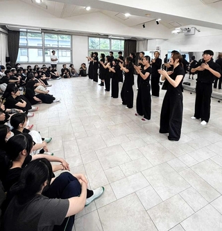 近大豊岡高校のダンス部員に踊りを披露する韓国の「ノマド・ビレッジ」の若者たち＝豊岡市戸牧（小山俊和さん提供）