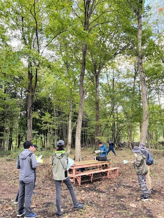 森林整備の現場を見学するモニターツアーの参加者たち＝豊岡市日高地域（日高神鍋観光協会提供）