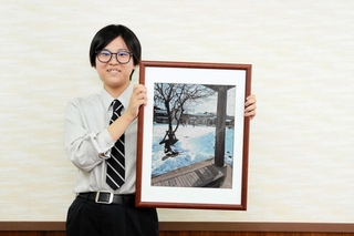 全国高校総合文化祭に出品する油彩の写真を手にした稲穂凉香さん＝豊岡市加広町