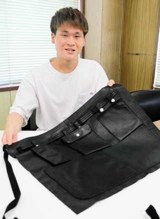 傷などで規格外になっていた上質な国産牛革を活用しようと製作されたエプロン＝豊岡市小田井町