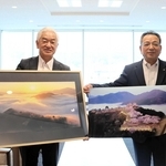 朝来市に写真を寄贈した谷吉將さん（左）と受け取った藤岡勇市長＝同市役所（同市提供）