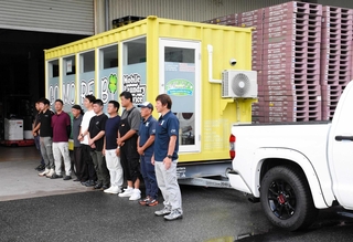 移動式ランドリーの前で出発のあいさつをする関係者ら＝養父市養父市場