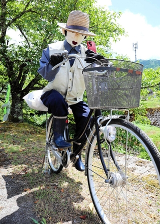 自転車の交通反則切符（青切符）制度の導入を受け、走行中にスマートフォンを使う「ながら運転」をしないよう注意するかかし＝朝来市納座