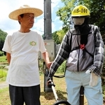制作したかかしと並ぶ納座区長の安保衛さん＝朝来市納座