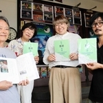 「私の豊劇物語」の１作目を手にするプロジェクトのメンバー＝豊岡市元町