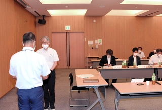 委員長に選ばれ、春名常洋管理者（手前）から諮問書を手渡される石田岳史教授＝公立八鹿病院