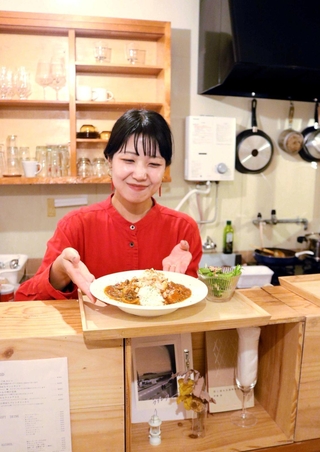 夜の喫茶店「街灯（マチノアカリ）」をオープンした佐藤春華さん。日替わりカレーや定食を用意する＝豊岡市野田