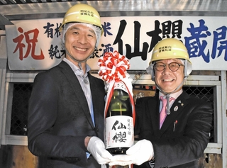 蔵出しした「仙櫻」を手にする山陽盃酒造の壷阪雄一社長（左）と養父市の大林賢一市長＝同市大屋町明延