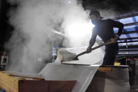 湯気がもうもうと立ちこめるなか、作業する蔵人＝山名酒造