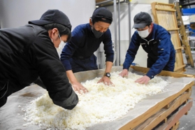 酒米を広げ、冷ましていく＝山名酒造