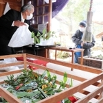 お参り後、福笹やお守りを買い求める参拝客ら＝達身寺