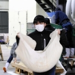 麹菌がかかった酒米を急いで運ぶ＝山名酒造（撮影・久保田輝）