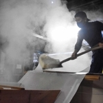 湯気がもうもうと立ちこめるなか、作業する蔵人＝山名酒造