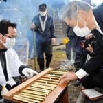 竹筒に入った粥（かゆ）の量を確かめる氏子ら＝折杉神社