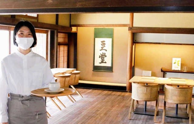 新設されたカフェ「小田垣豆堂」の店内。杉本さんは掛け軸に「豆堂」と筆をふるった＝丹波篠山市立町
