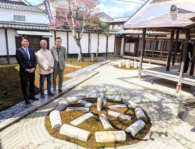 縄文遺跡の環状列石をイメージした石庭に立つ（左から）「小田垣商店」の小田垣昇社長と、改修を手掛けた美術家杉本博司さん、建築家榊田倫之さん＝丹波篠山市立町