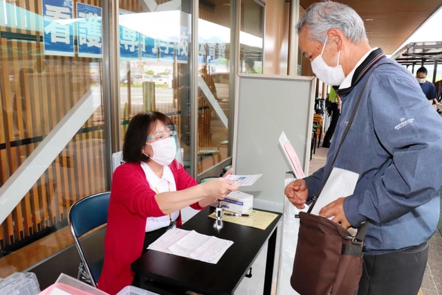 受付では、運転免許証などで本人確認が行われる＝丹波市立看護専門学校体育館