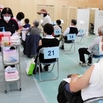 問診後は左腕を出して椅子に座り、接種の順番を待つ＝丹波市立看護専門学校体育館