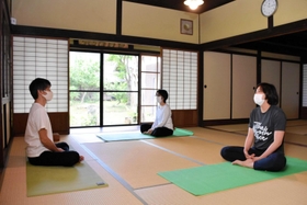 ヨガ教室で受講者とともに瞑想する渡辺顕さん（左）＝丹波市春日町棚原、本上田邸