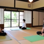 ヨガ教室で受講者とともに瞑想する渡辺顕さん（左）＝丹波市春日町棚原、本上田邸