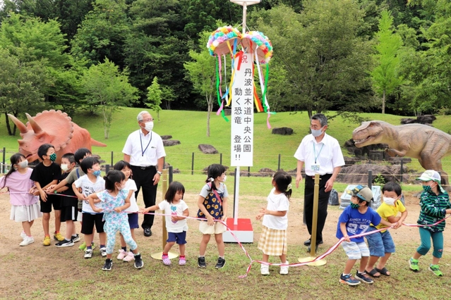 ３日の恐竜模型のお披露目会では、くす玉が割られた＝丹波並木道中央公園
