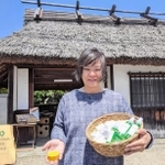 長屋門の前で、自慢のせっけんなどを手にした「ささやまビーファーム」の松村社長＝丹波篠山市北新町