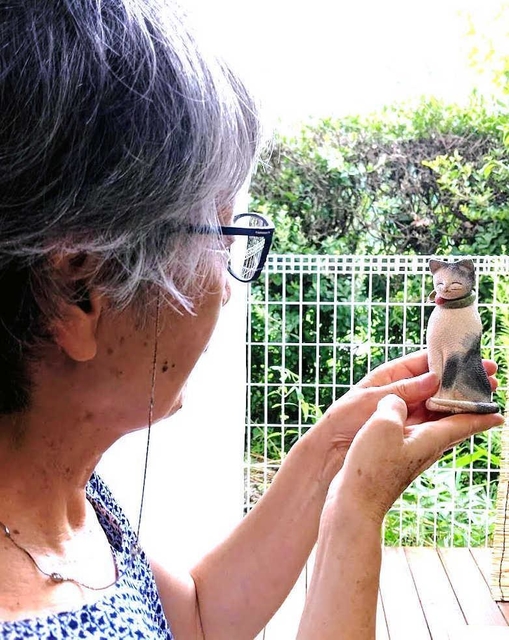 ネコをかたどった自作を眺める濱田さん。作品の購入者が“里帰り”だといって届けてくれた＝丹波篠山市内