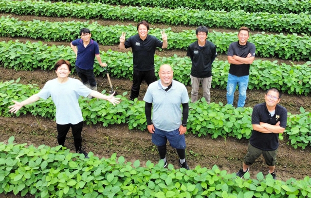 青々とした豆畑に立つ「デカンショ豆」の生産農家ら＝丹波篠山市内