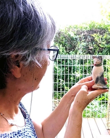 ネコをかたどった自作を眺める濱田さん。作品の購入者が“里帰り”だといって届けてくれた＝丹波篠山市内
