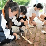 「弓切り式」の道具で火をおこす柏原高の生徒たち＝丹波市春日町黒井