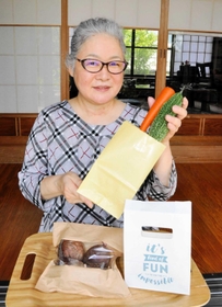 袋メーカーから無償提供を受ける３種類の紙袋を持つ西野裕子さん＝丹波市