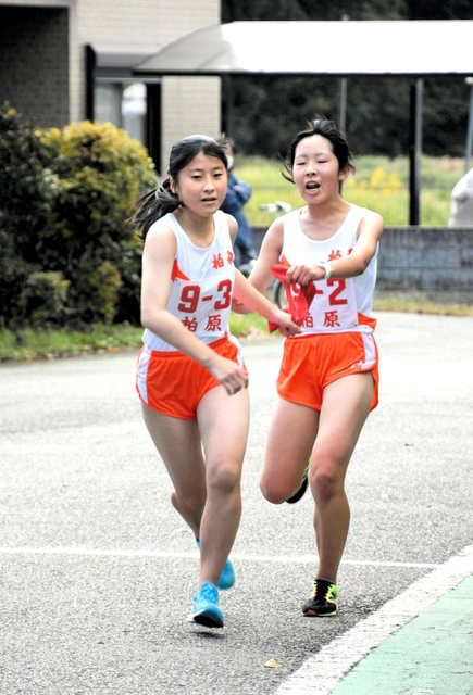 柏原女子２区の荻野弥空選手（右）からたすきを受ける３区の婦木陽加選手＝丹波篠山市寺内