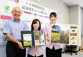 記念切手シートを受け取った酒井隆明市長（左）＝丹波篠山市役所