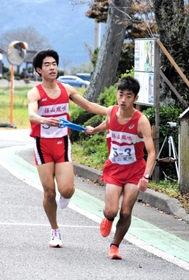 篠山鳳鳴男子２区の堂本翔太選手（左）からたすきを受ける３区の荒木光選手＝丹波篠山市寺内