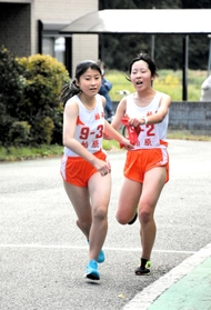 柏原女子２区の荻野弥空選手（右）からたすきを受ける３区の婦木陽加選手＝丹波篠山市寺内