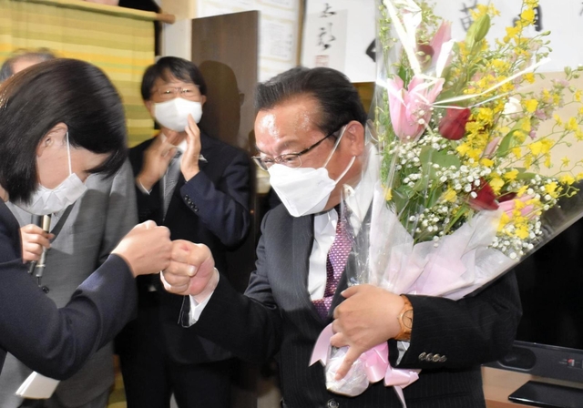 支援者とグータッチをして喜ぶ谷公一氏＝豊岡市塩津町（撮影・石川　翠）