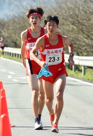 男子・篠山鳳鳴の２区谷口絢哉選手（左）からたすきを受け取る３区木下温喜選手＝丹波篠山市内（撮影・坂井萌香）