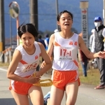 女子・柏原の１区檜田菜奈選手（右）からたすきを受け取る２区中尾友香主将＝丹波篠山市内（撮影・吉田敦史）